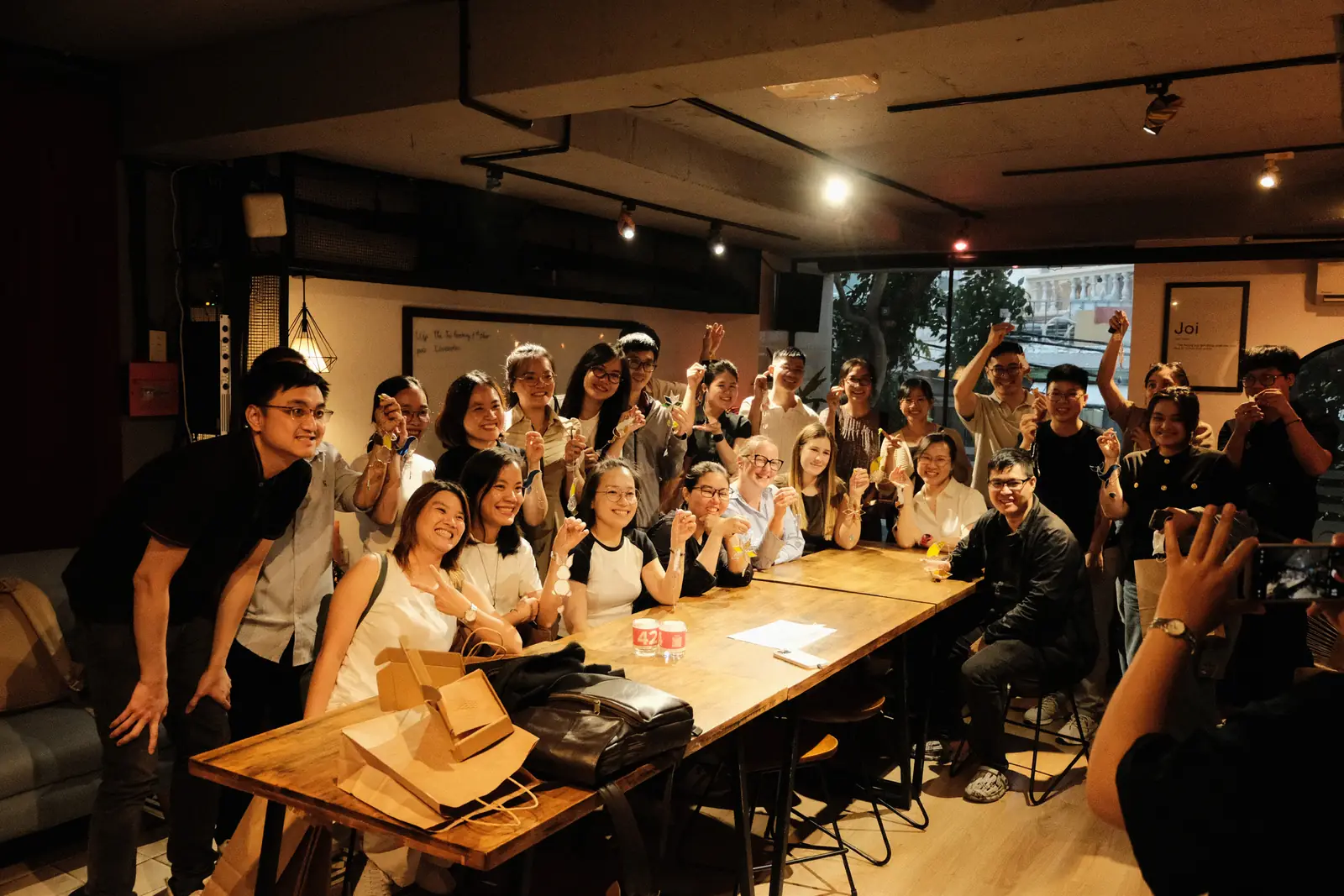 Một lớp workshop đông người quanh bàn dài trong atelier